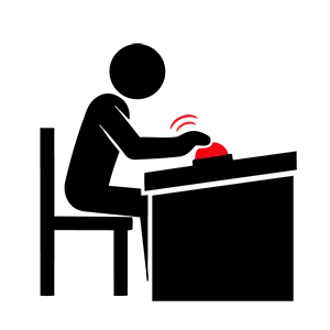 机に座って赤い早押しボタンを押しクイズに回答しようとしている人のピクトグラム